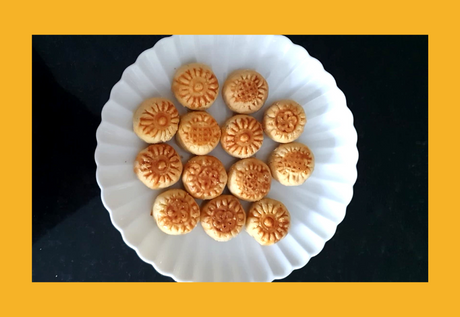 Plate of round bite sized golden pineapple tarts.